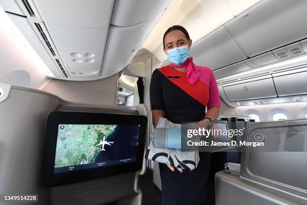 Qantas cabin crew member presents an amenity kit and pyjamas on board a Boeing 787 Dreamliner aircraft during a media visit on October 28, 2021 in...