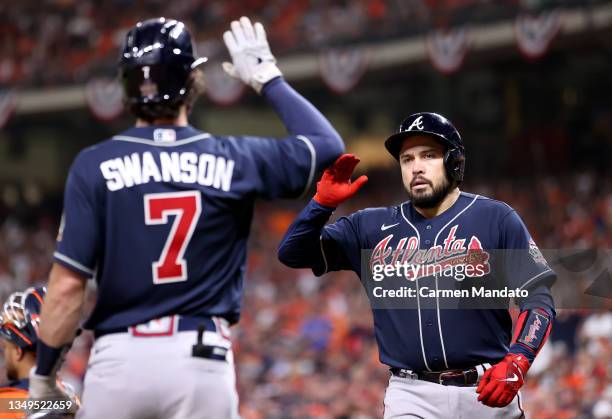 Travis d'Arnaud of the Atlanta Braves is congratulated by Dansby Swanson after hitting a one run home run against the Houston Astros during the...