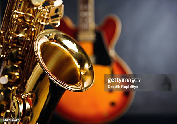 close up on saxophone with guitar in background. jazz rules! - saxofoon stockfoto's en -beelden