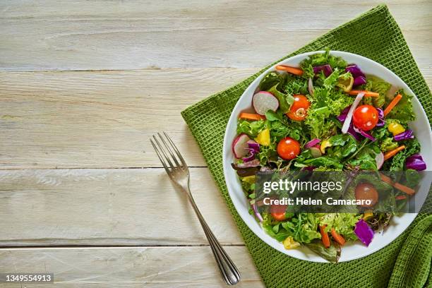 top view of fresh and healthy salad in a bowl on wooden table. - salad bowl stock pictures, royalty-free photos & images