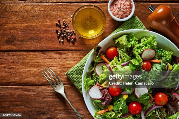 top view of fresh and healthy salad in a bowl on wooden table. - salada imagens e fotografias de stock