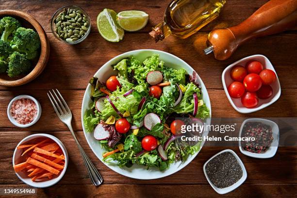 top view of fresh and healthy salad in a bowl on wooden table. - chia seed oil stock pictures, royalty-free photos & images