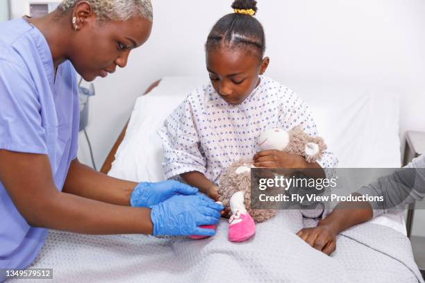 kind nurse providing comfort to young sick girl in hospital - pediatric intensive care unit stock pictures, royalty-free photos & images