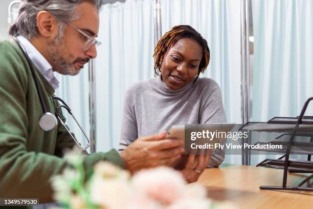 une patiente examine les résultats des tests m�édicaux avec son médecin - doctor and patient talking photos et images de collection