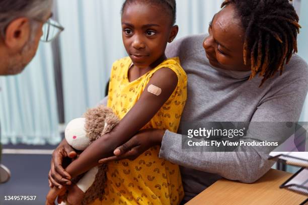 portrait of young black girl with bandage after getting the flu vaccine - black children stock pictures, royalty-free photos & images
