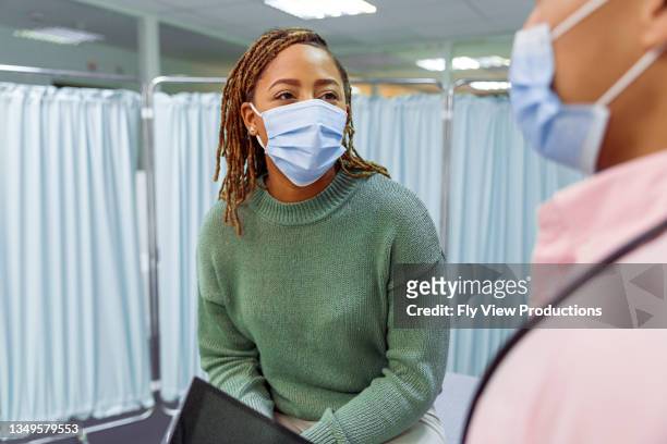 woman being discharged from hospital speaking with doctor - hospital mask stock pictures, royalty-free photos & images
