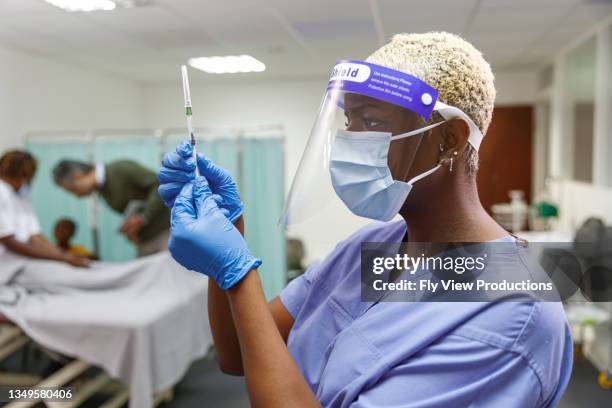 nurse preparing to give hospitalized patient a vaccination - male medical professional stock pictures, royalty-free photos & images