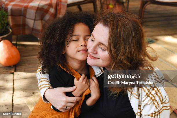 a black child with a white mom is hugging. - big hug stock pictures, royalty-free photos & images