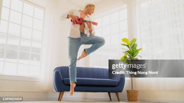 a young male ballet dancer practice in his room, wearing headphones having fun on dance. - asian male dancer stock-fotos und bilder