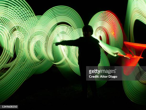 child pointing out with his index finger in one direction in a futuristic, virtual robotic environment. 3d. light painting - innovation stock-fotos und bilder