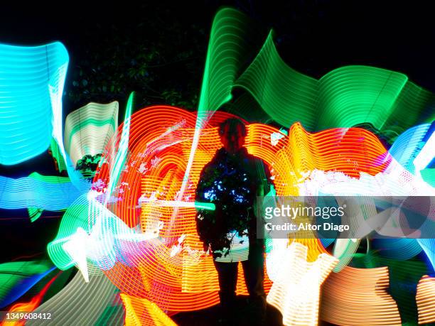 progress / innovation versus sustainability concept. human  in a futuristic, virtual robotic environment with a tree in the background. 3d. light painting - active silhouettes stock pictures, royalty-free photos & images