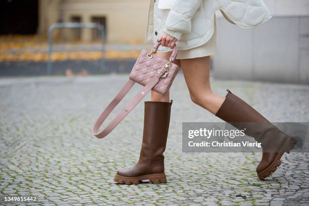 Mandy Bork is seen wearing Lady Dior bag and Dior jumper, white Frankie shop jacket and shorts, Bottega Veneta sunglasses, brown Giaborghini boots on...