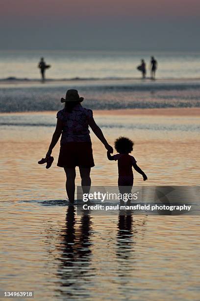 mother and daughter enjoy evening paddle in sea - brighton beach foto e immagini stock