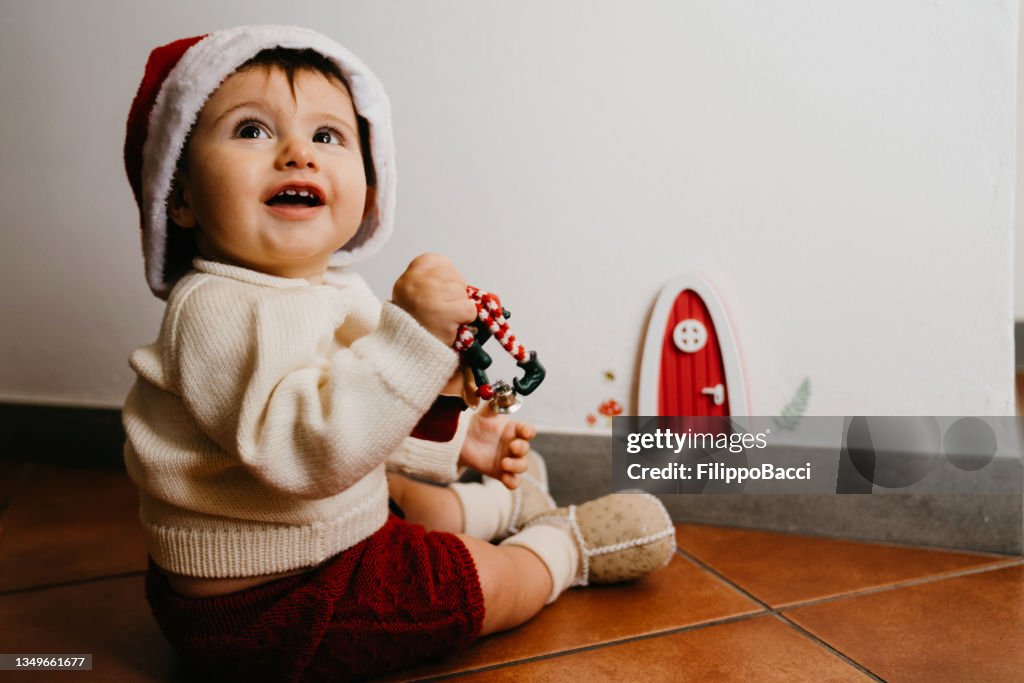 Kleines Kind, das in der Nähe einer Gnomentür sitzt