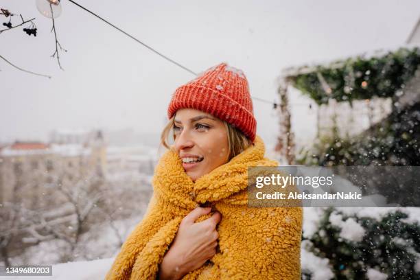 young woman wrapped in a blanket on the terrace on a cold snowy day - wrapped in a blanket stock pictures, royalty-free photos & images
