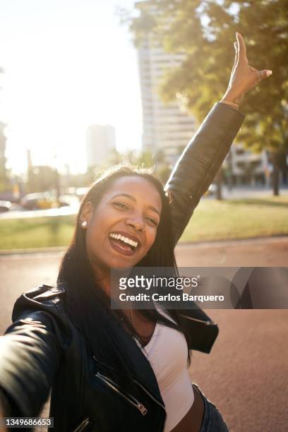 young  latin american woman taking a selfie. concept of enjoying life and on vacation. - dark skin stock pictures, royalty-free photos & images