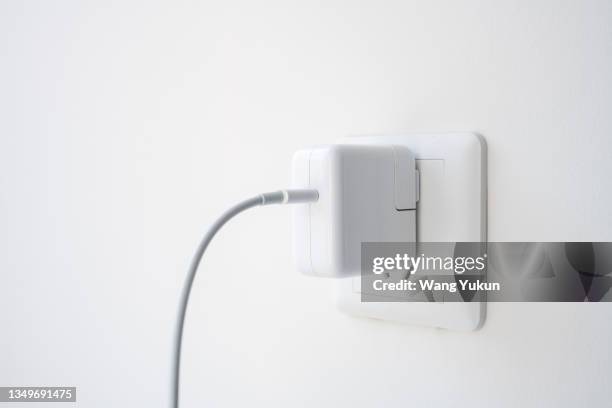 the charger is plugged into the socket - power point foto e immagini stock