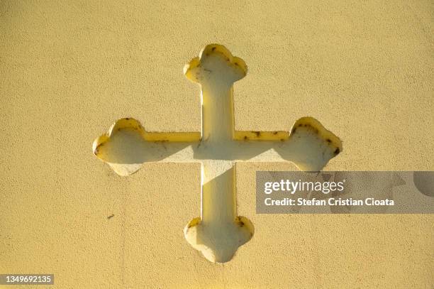 cross carved in a yellow wall - orthodox photos et images de collection