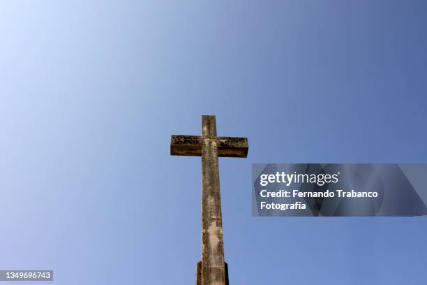 cross under a blue sky - misa fotografías e imágenes de stock