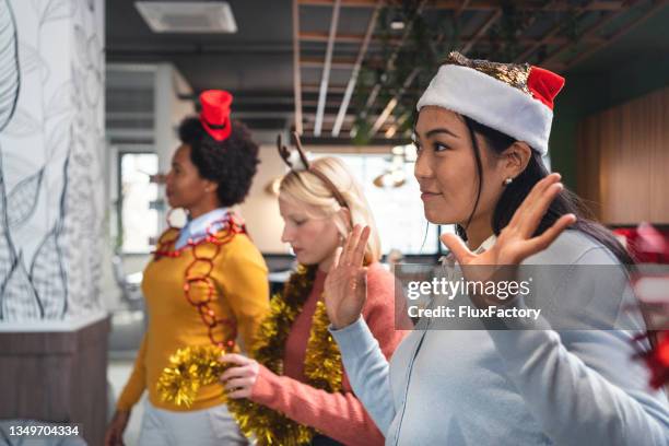 modern and serene multiracial businesswomen dancing during christmas office party - christmas office party stock pictures, royalty-free photos & images