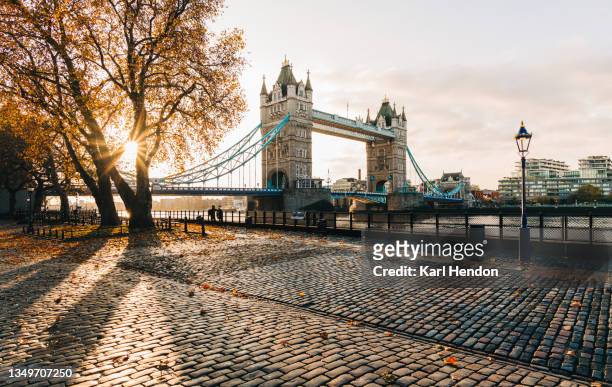 a sunrise view autumn leaves at london's tower bridge - stock photo - london stockfoto's en -beelden