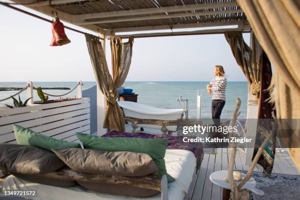 woman enjoying the view from terrace with sea view in punta secca, sicily, italy - camping de lujo fotografías e imágenes de stock