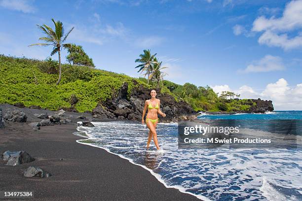 woman in bikini walking on beach - black sand stock pictures, royalty-free photos & images