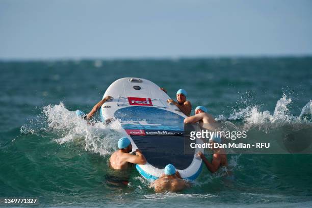 England players swim giant paddleboards out to a bouy during the England Rugby training camp on October 27, 2021 in St Brelade, Jersey.