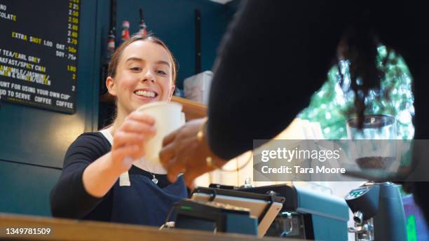 woman serving coffee to customer - barista coffee restaurant stockfoto's en -beelden