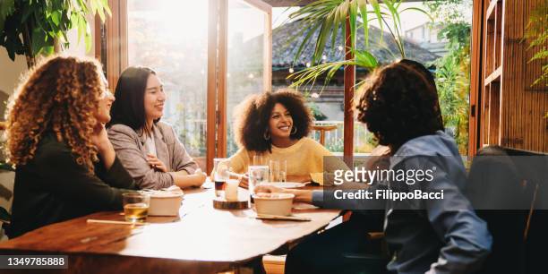 a group of friends during a dinner party together - afro friends home stock pictures, royalty-free photos & images