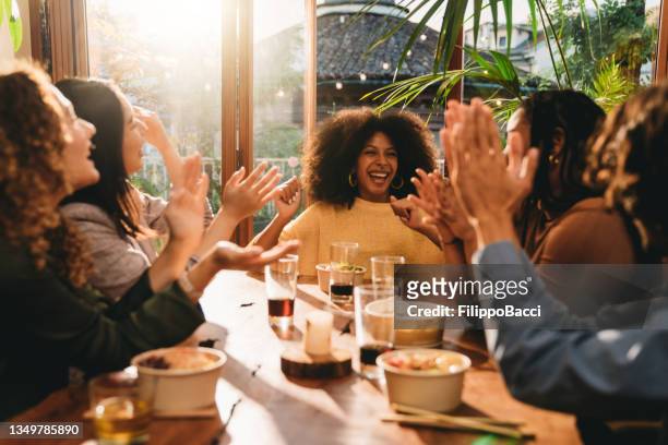 a young woman with afro hair is celebrating the achievement of her last milestone - victory dinner stockfoto's en -beelden
