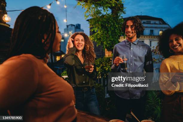 eine gruppe von freunden während einer dinnerparty auf einem dach in der stadt - sunset freinds city stock-fotos und bilder