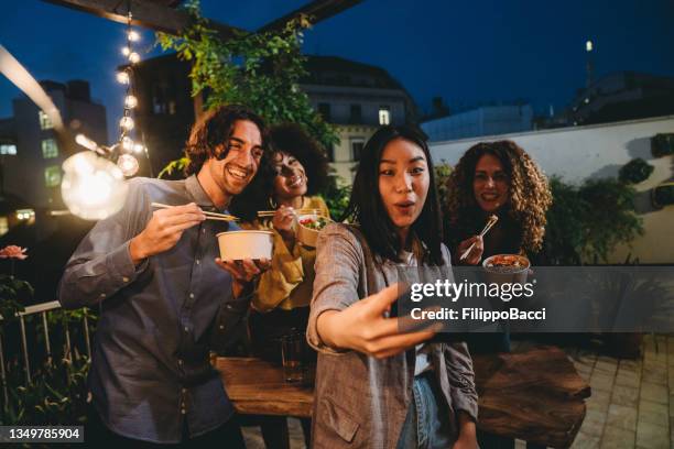 un gruppo di amici si sta facendo un selfie durante una cena sul tetto - rooftop dining foto e immagini stock