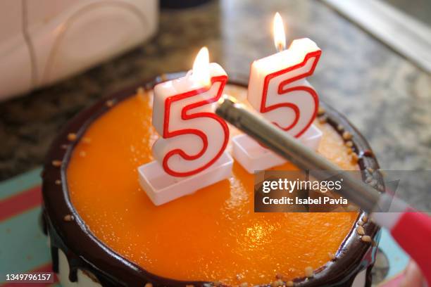 hand burning 55 birthday candles with a lighter - number 55 stock pictures, royalty-free photos & images