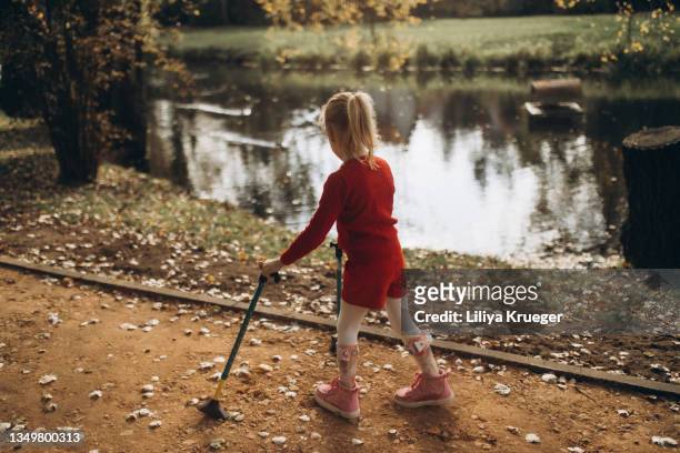 girl with cerebral palsy walks in the autumn park. - cerebral palsy stock pictures, royalty-free photos & images