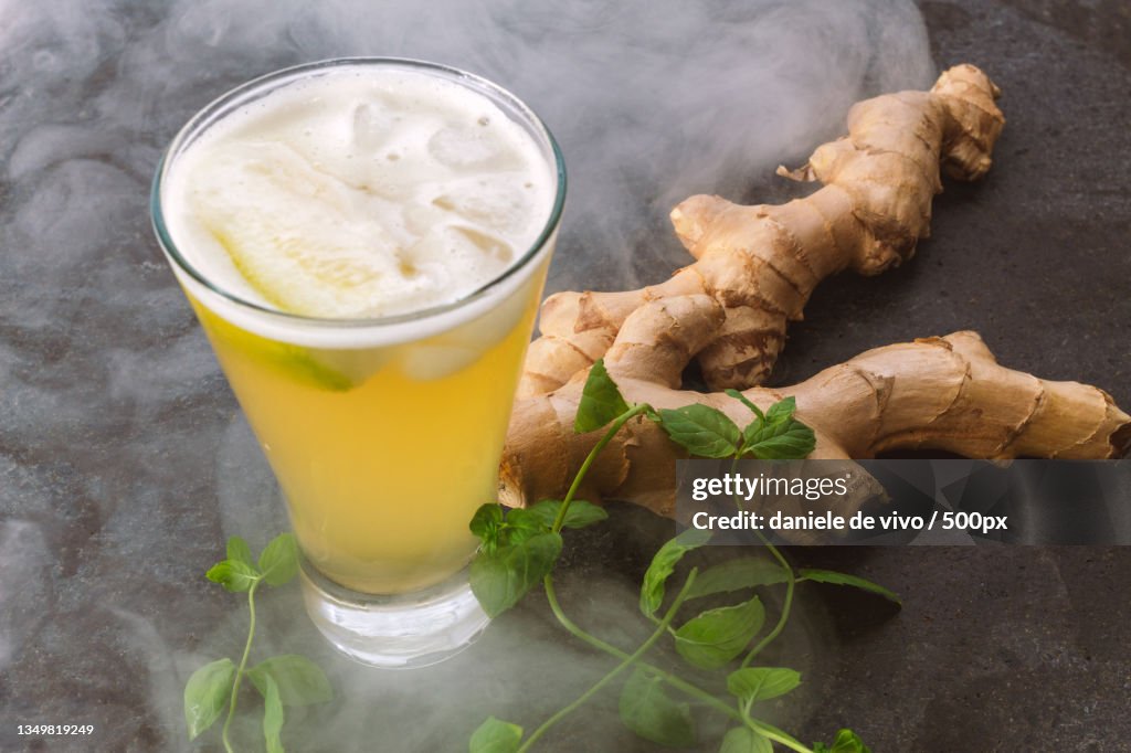 Close-up of drink with ginger and leaves on table