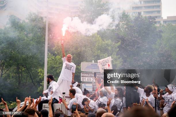 Mounia, mother of Nahel shot by a police officer, holds a flare during a demonstration in the Nanterre suburb of Paris, France, on Thursday, June 29,...