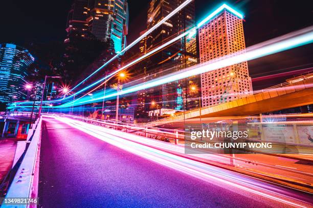 traffic trails in financial district - tail light stock pictures, royalty-free photos & images