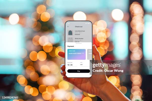 doing christmas shopping online with smart phone - shopping smartphone photos et images de collection