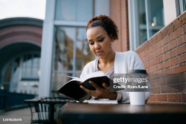 woman studying at outdoor urban cafe - bible stock pictures, royalty-free photos & images