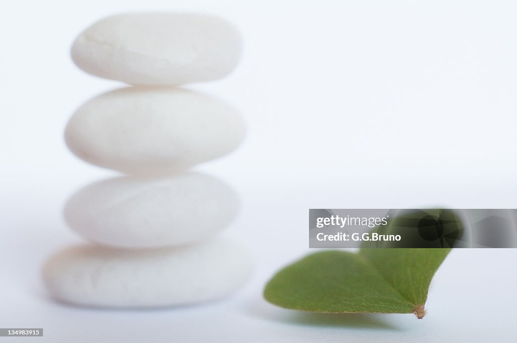 Stack of white pebbles and heart shaped clover