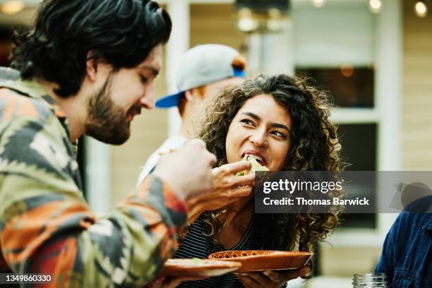 medium close up shot of woman eating tacos with friends at food truck - day 20 fotografías e imágenes de stock