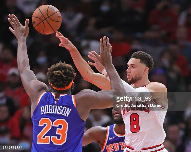 Zach LaVine of the Chicago Bulls passes over Mitchell Robinson of the New York Knicks at the United Center on October 28, 2021 in Chicago, Illinois....