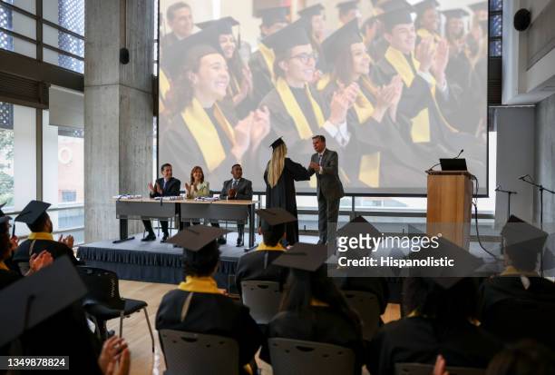 graduating student receiving her diploma and handshaking the hand of a professor - receiving diploma stock pictures, royalty-free photos & images