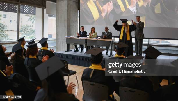 very happy female student celebrating getting her diploma in the graduation ceremony - receiving diploma stock pictures, royalty-free photos & images