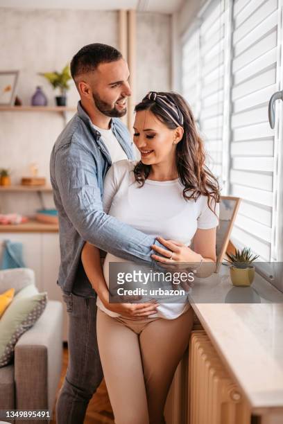 young happy couple expecting baby - young couple with baby stock pictures, royalty-free photos & images