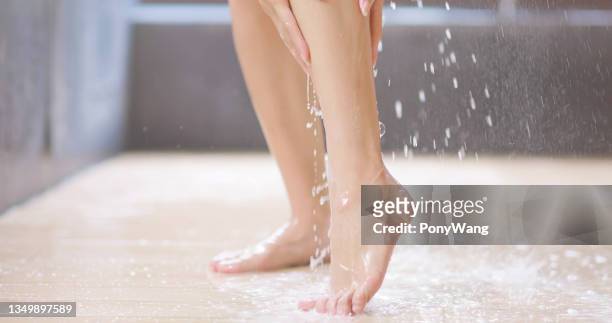mujer de belleza tomar ducha - piernas de mujer fotografías e imágenes de stock