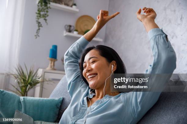 jeune femme s’imaginant être dans un club de danse tout en écoutant de la musique à la maison - aqua dance photos et images de collection