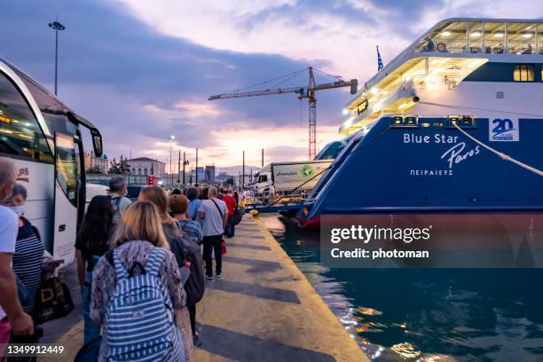 people waiting in line to embarking the paros catamaran of blue star ferries at dusk - greece message stock pictures, royalty-free photos & images