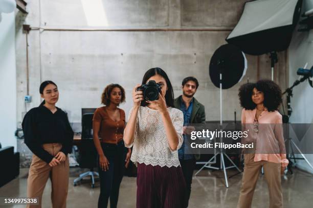 a woman photographer in her studio with a camera - fashion photographer stock pictures, royalty-free photos & images